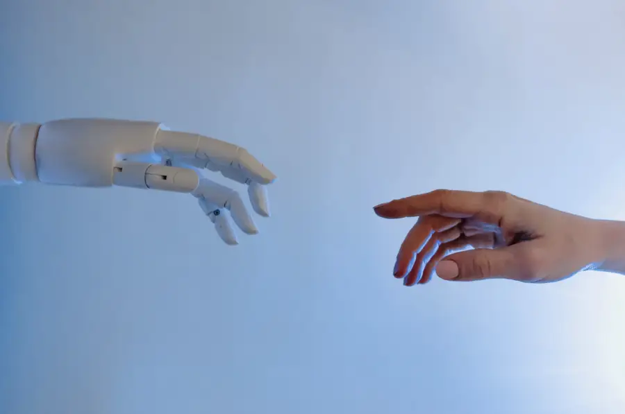 Robot hand and human hand reaching out, symbolising the connection between AI and tradies.