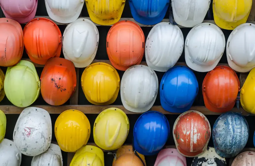 Forty construction hats arranged neatly, symbolising workplace safety for tradies.